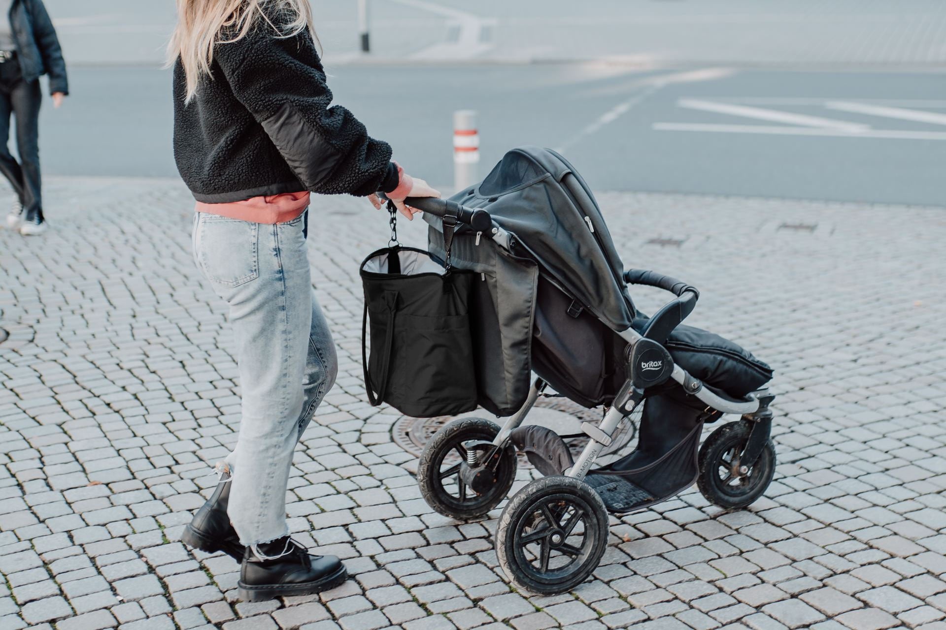 Wickeltasche Greta in schwarz hängend am Kinderwagen