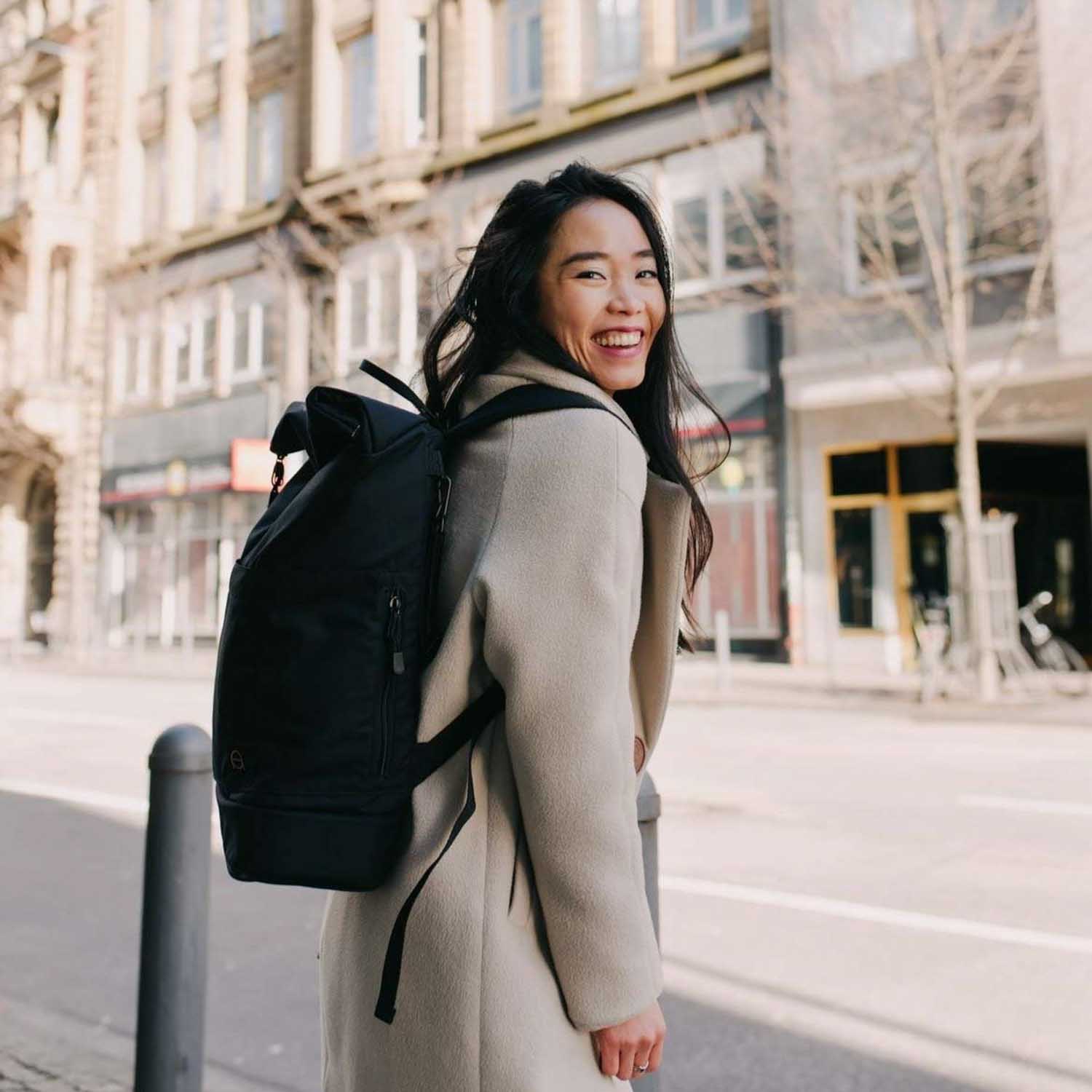 Großer Wickelrucksack Hugo in schwarz mit Rolltop. Fair produziert. Robust, unisex, wasserabweisend